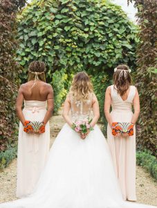 Photographe de mariage à courbevoie demoiselle d'honneur en ligne pose dans le parc des bagatelles à neuilly sur seines un bouquet dans le dos