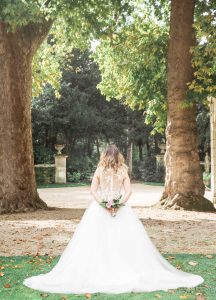 Photographe de mariage à courbevoie Photographe de naissance et mariage mariée de dos avec bouquet de fleur dans les mains parc des baguatelle neuilly sur seine
