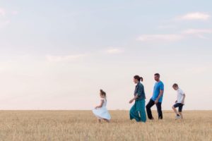 une famille marche dans u champs de blé