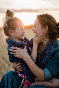 une maman prend sa fille dans ses bras