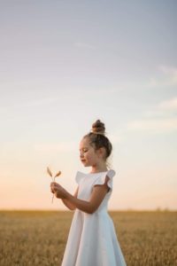 une enfant joue avec une fleur