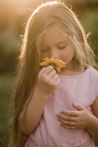 une enfant joue avec une fleur
