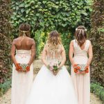 Photographe de mariage à courbevoie demoiselle d'honneur en ligne pose dans le parc des bagatelles à neuilly sur seines un bouquet dans le dos