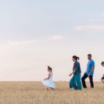 une famille marche dans u champs de blé