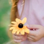 une enfant joue avec une fleur